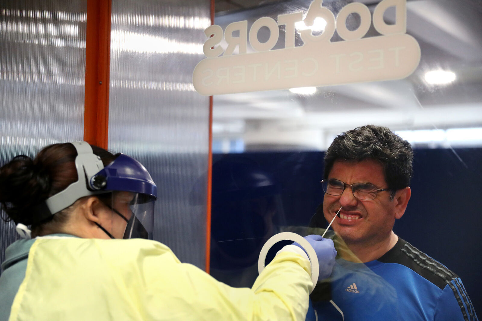 Luis Mostacero receives a Covid-19 test from testing technician Jamie Kunzer at Doctors Test Centers at Chicago's O'Hare International Airport on Thursday, May 20, 2021. Mostacero and his family were getting tested a day prior to their flight to Spain. The family is moving from Deerfield to Barcelona.
